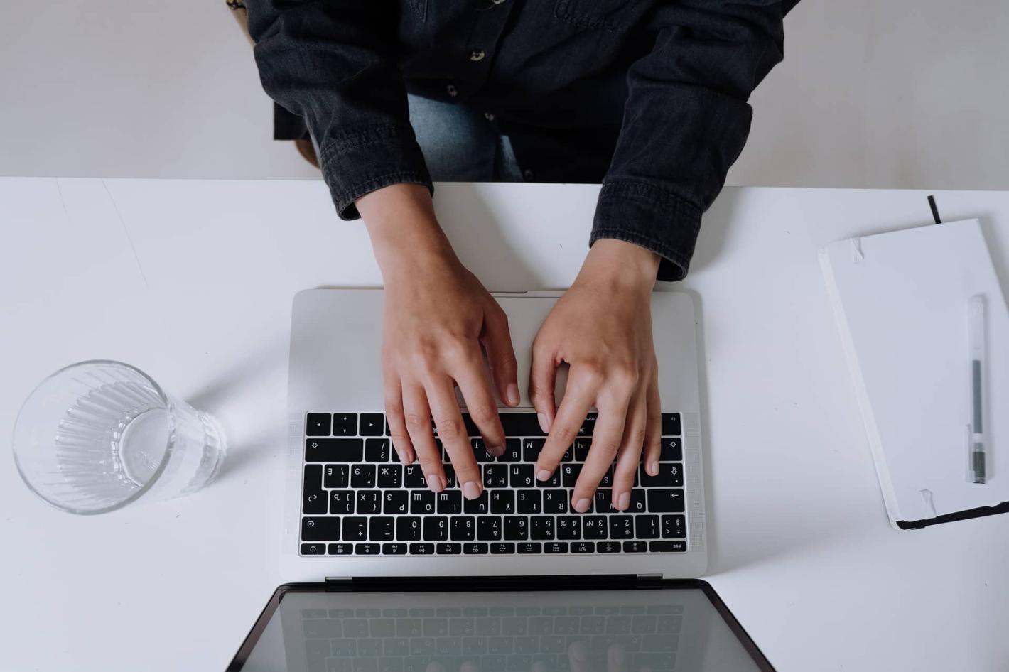 Mains qui tapent au clavier d'un ordinateur portable